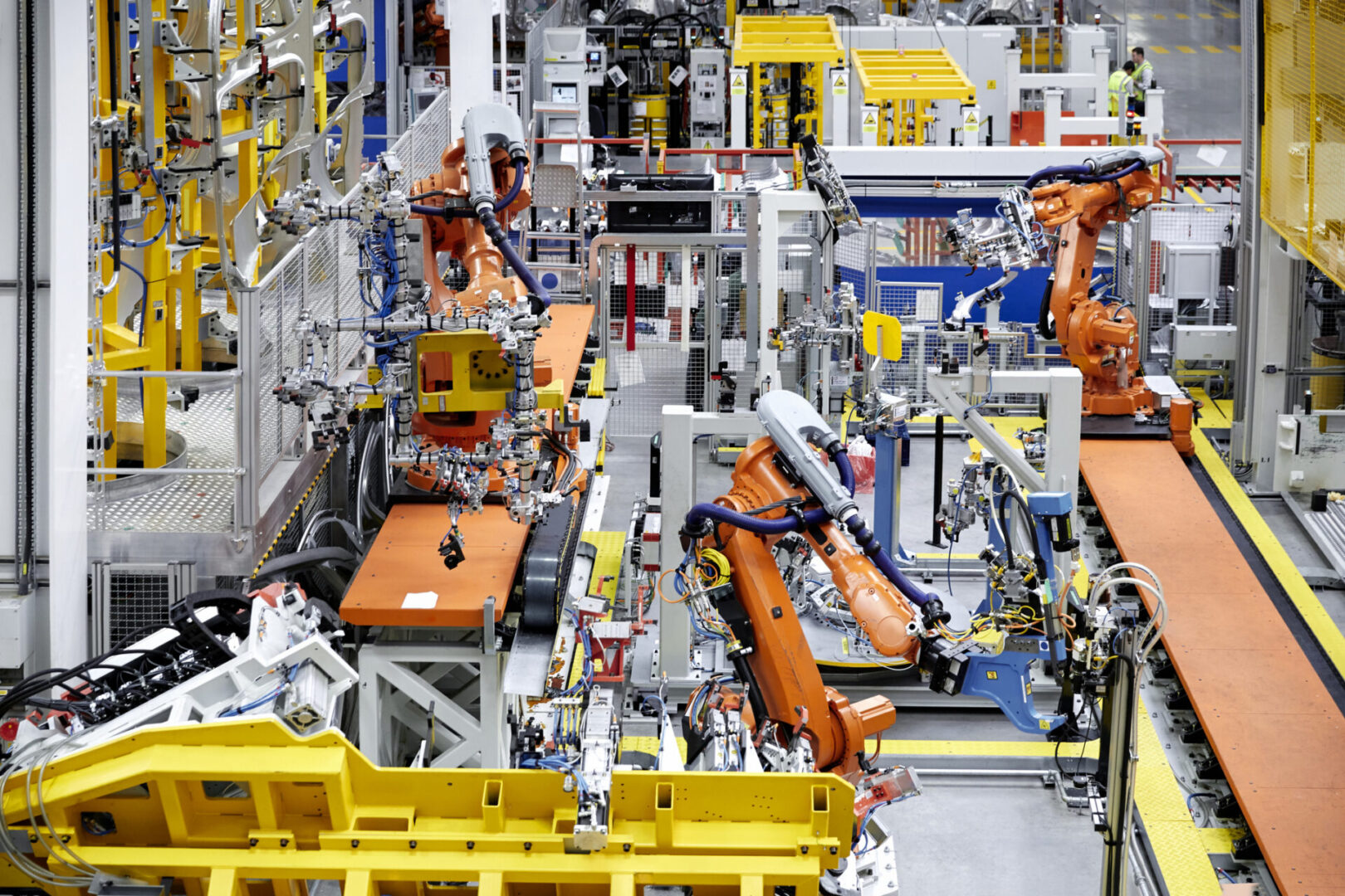 A factory floor with many machines and yellow parts.